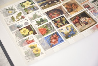 A collection of various collectible stamps displayed neatly in an album, featuring illustrations of flowers, plants, and scenes. The stamps are from different countries with a variety of colors and designs.