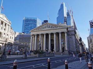a large building with columns and a statue in front of it with Royal Exchange, London in the background