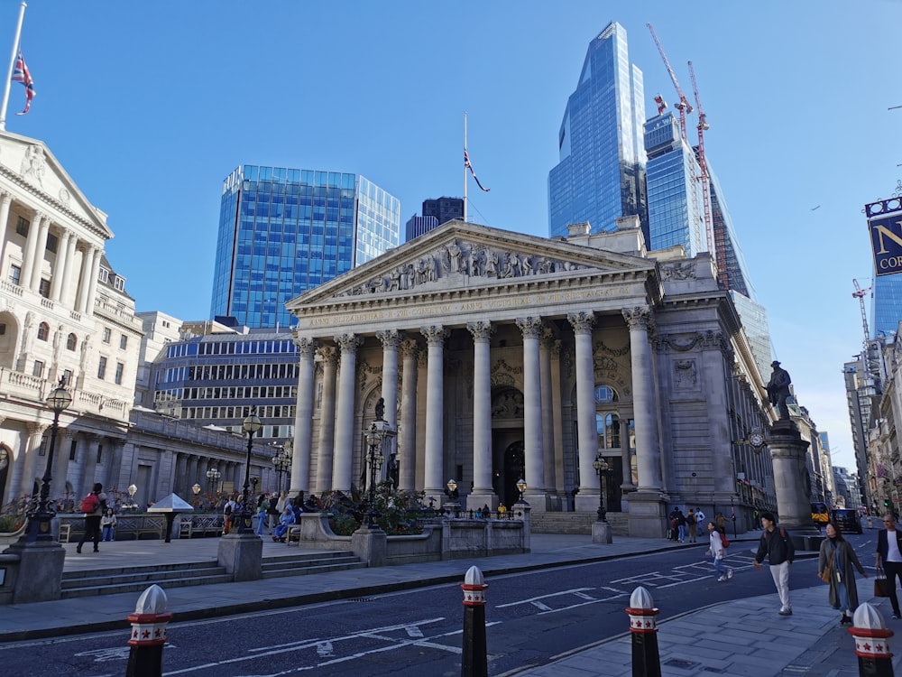 a large building with columns and a statue in front of it with Royal Exchange, London in the background