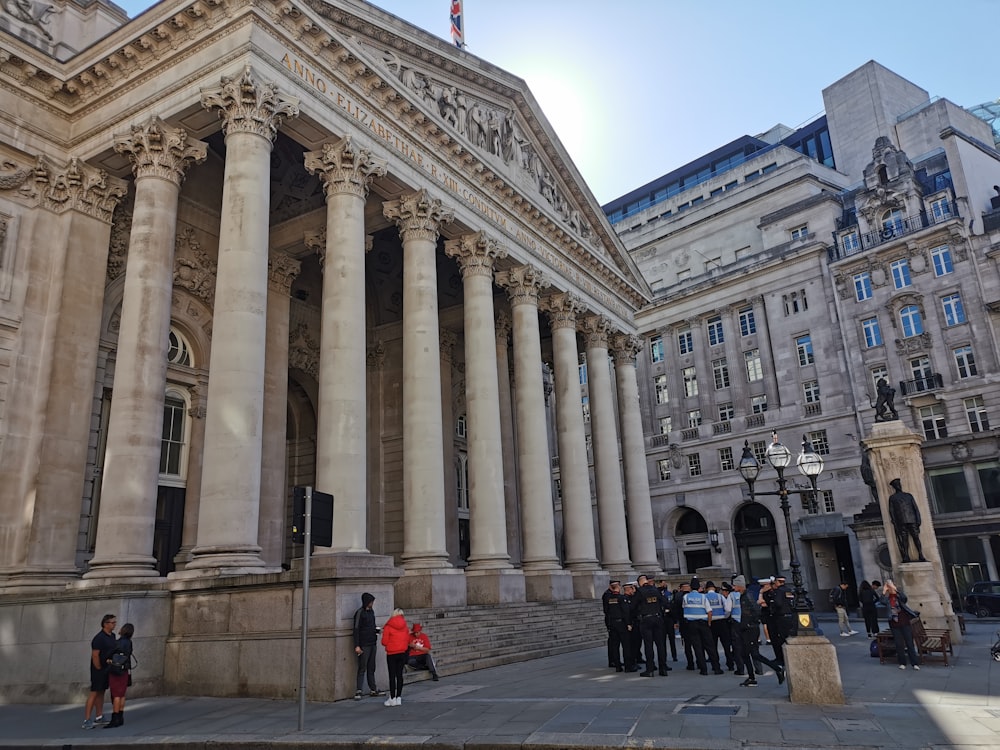 a large building with columns and people standing in front of it