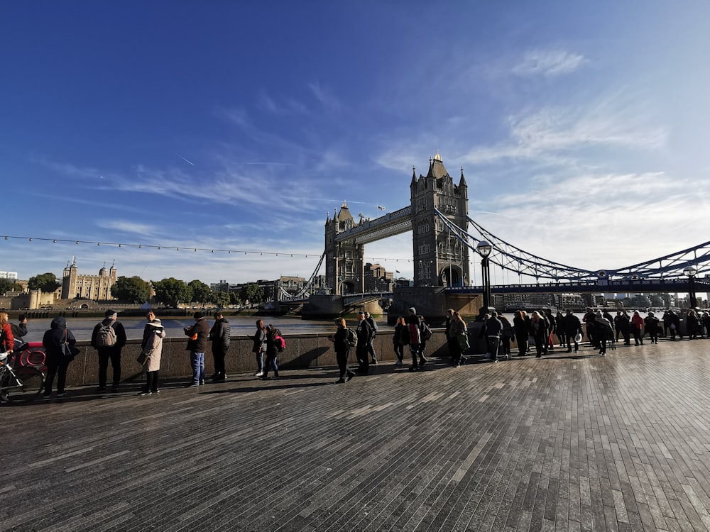 a group of people standing in front of a bridge