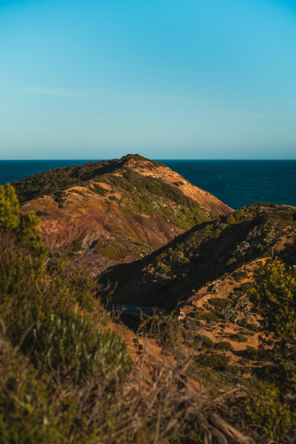 a cliff with a body of water in the background