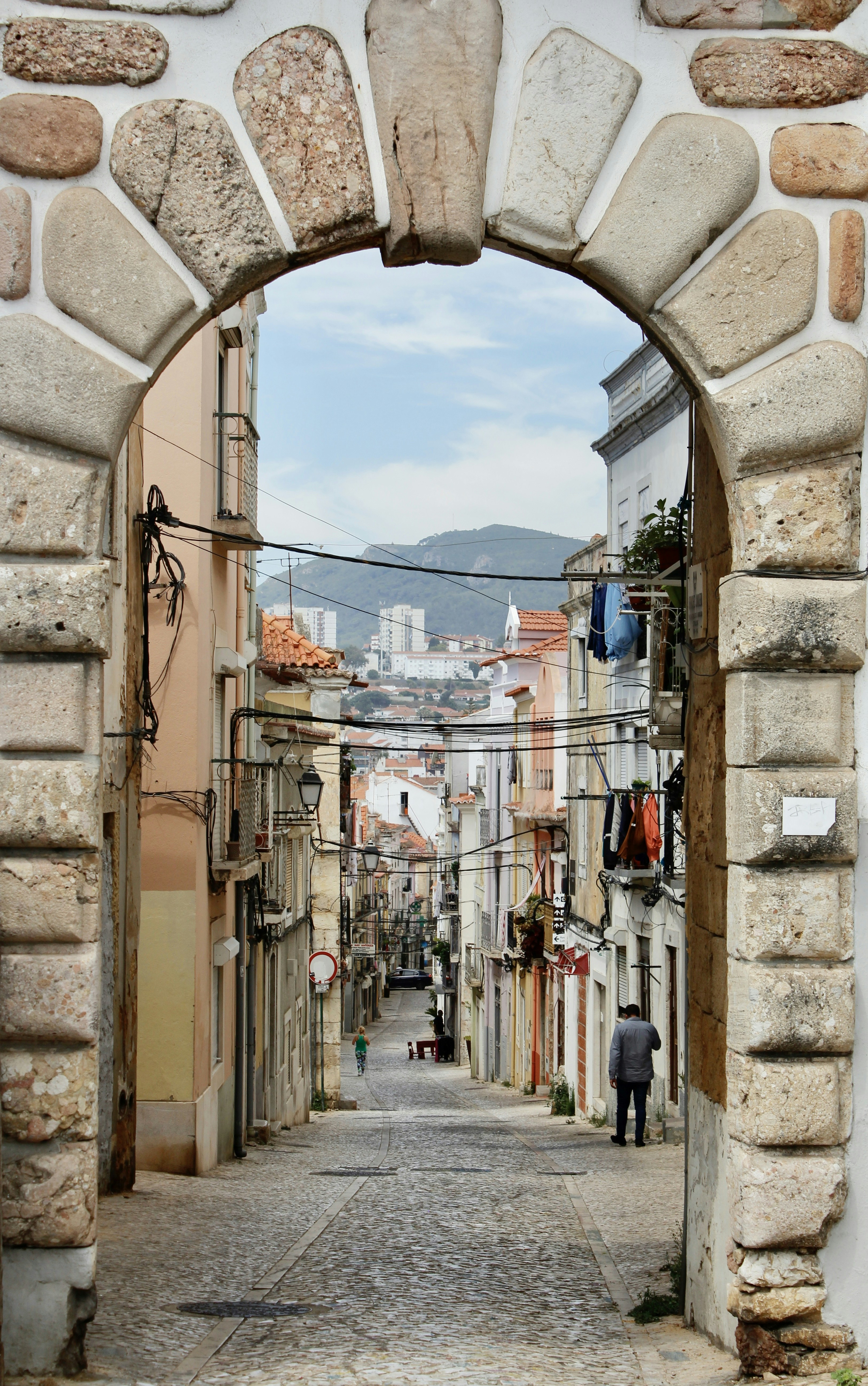 a person walking through an alley between stone buildings