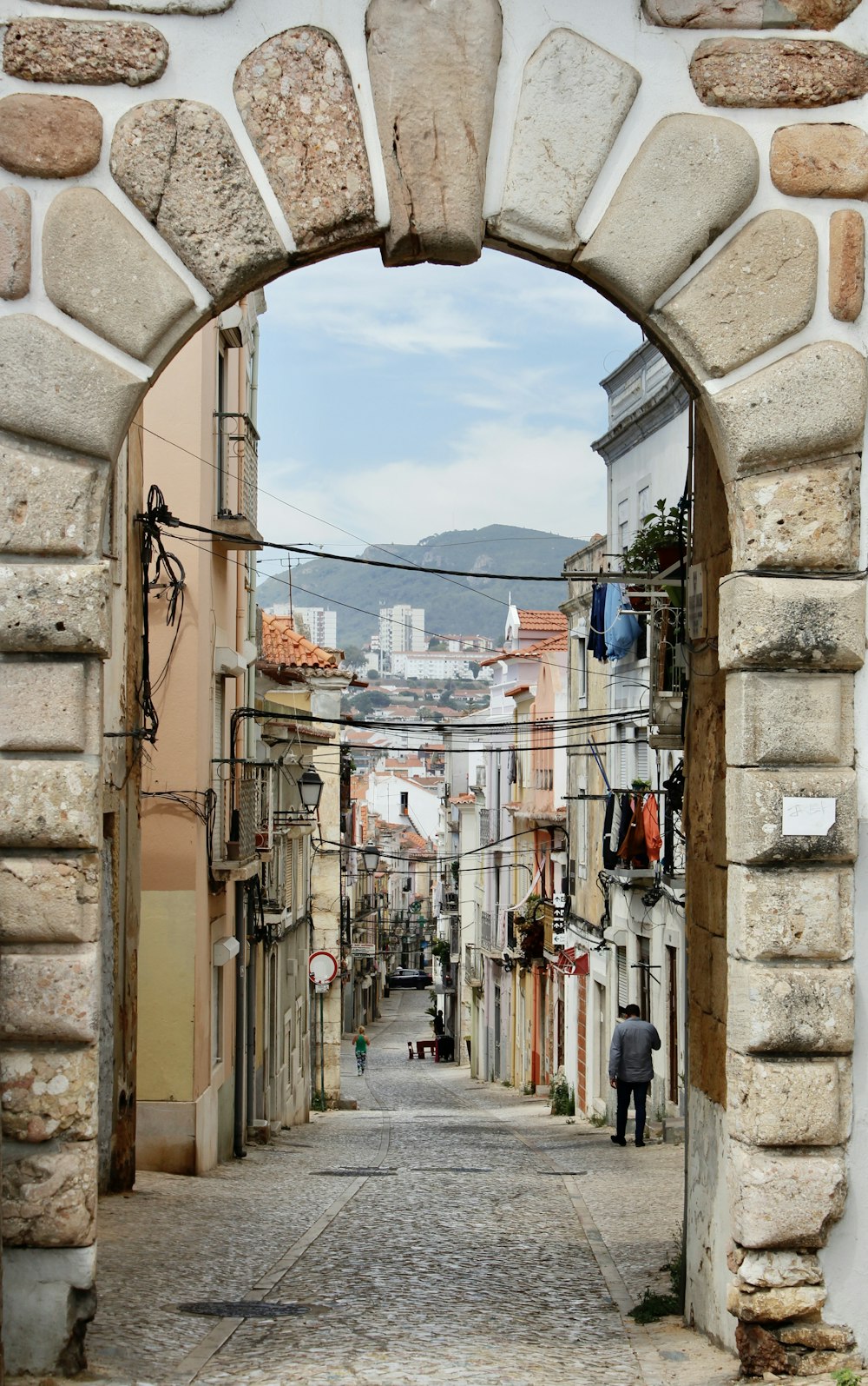 a person walking through an alley between stone buildings