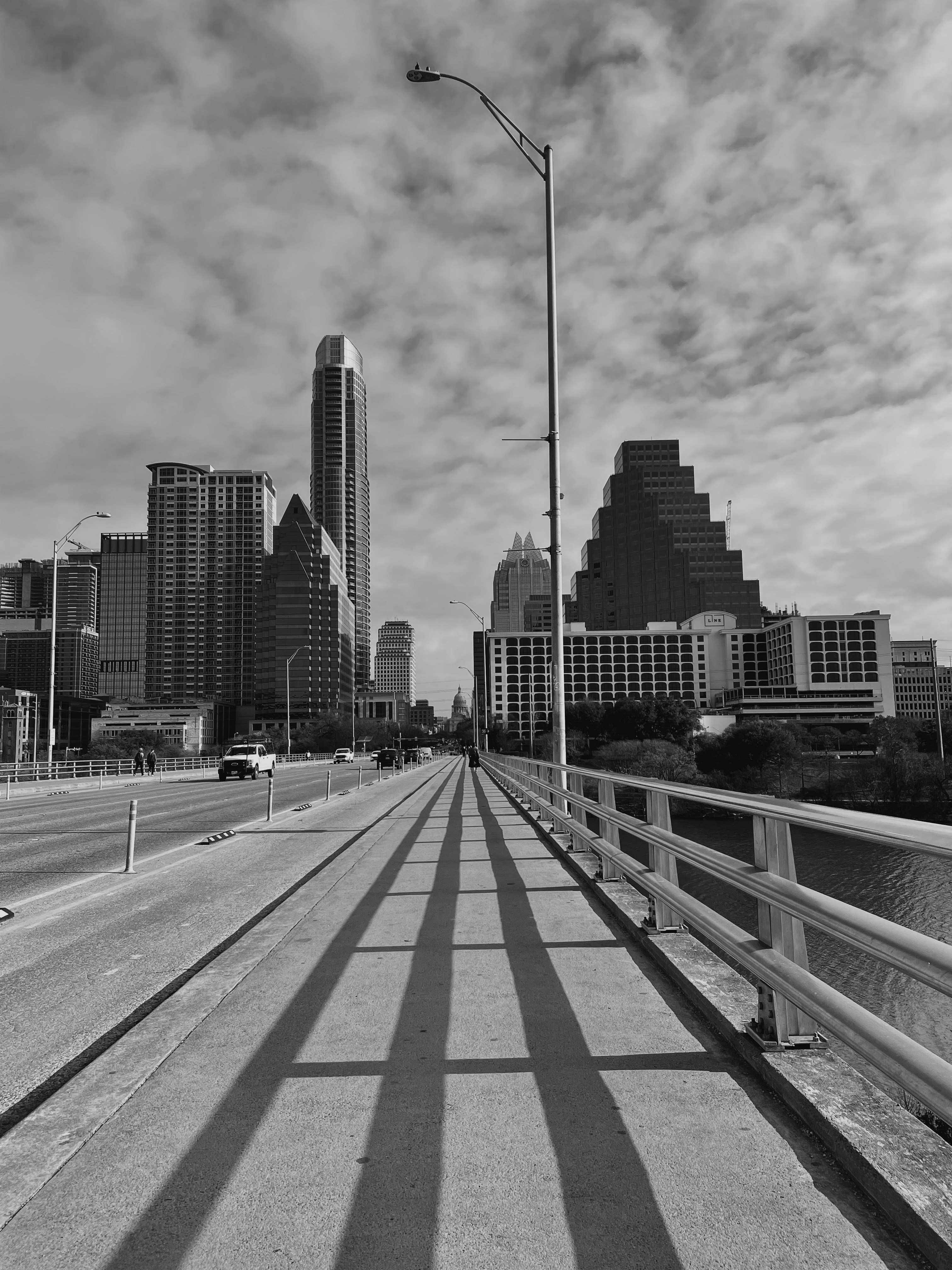 A road with a railing and buildings on the side photo – Free Road Image ...