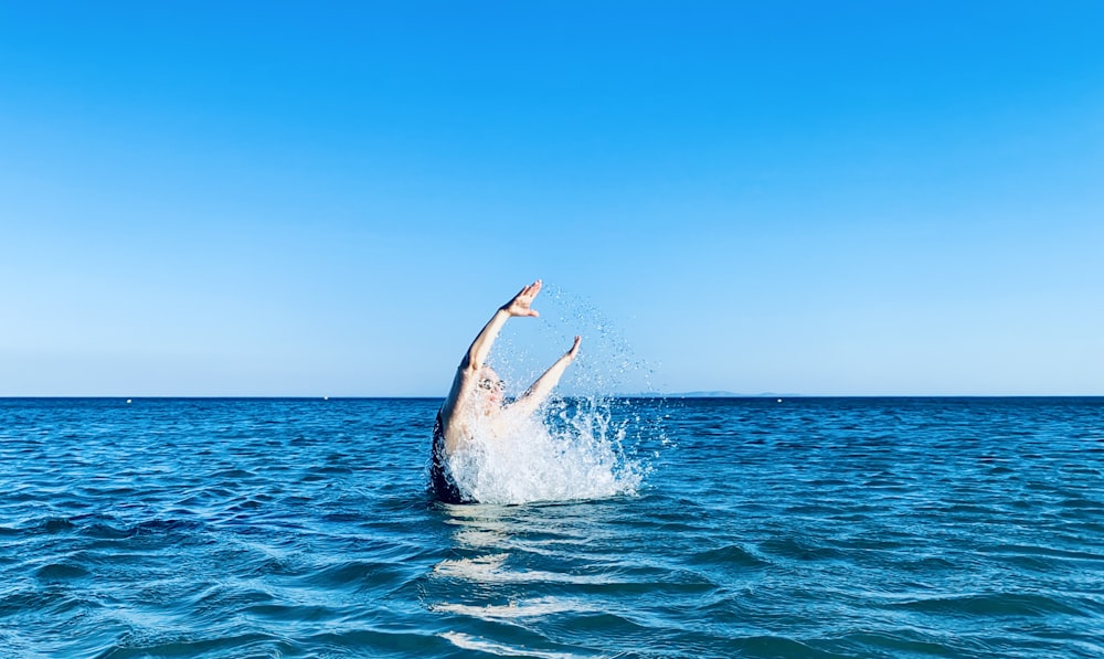 uma pessoa pulando para fora da água