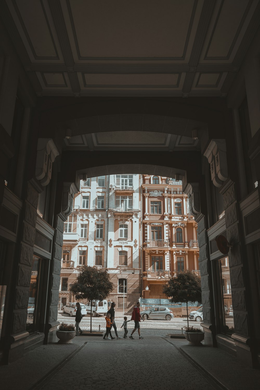 a group of people walking on a street between buildings