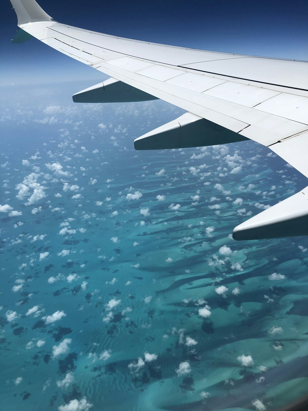 an airplane wing above the ocean