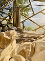 Interior view of a chalet room bathed in soft cream light with wooden beams and champagne gold accents.