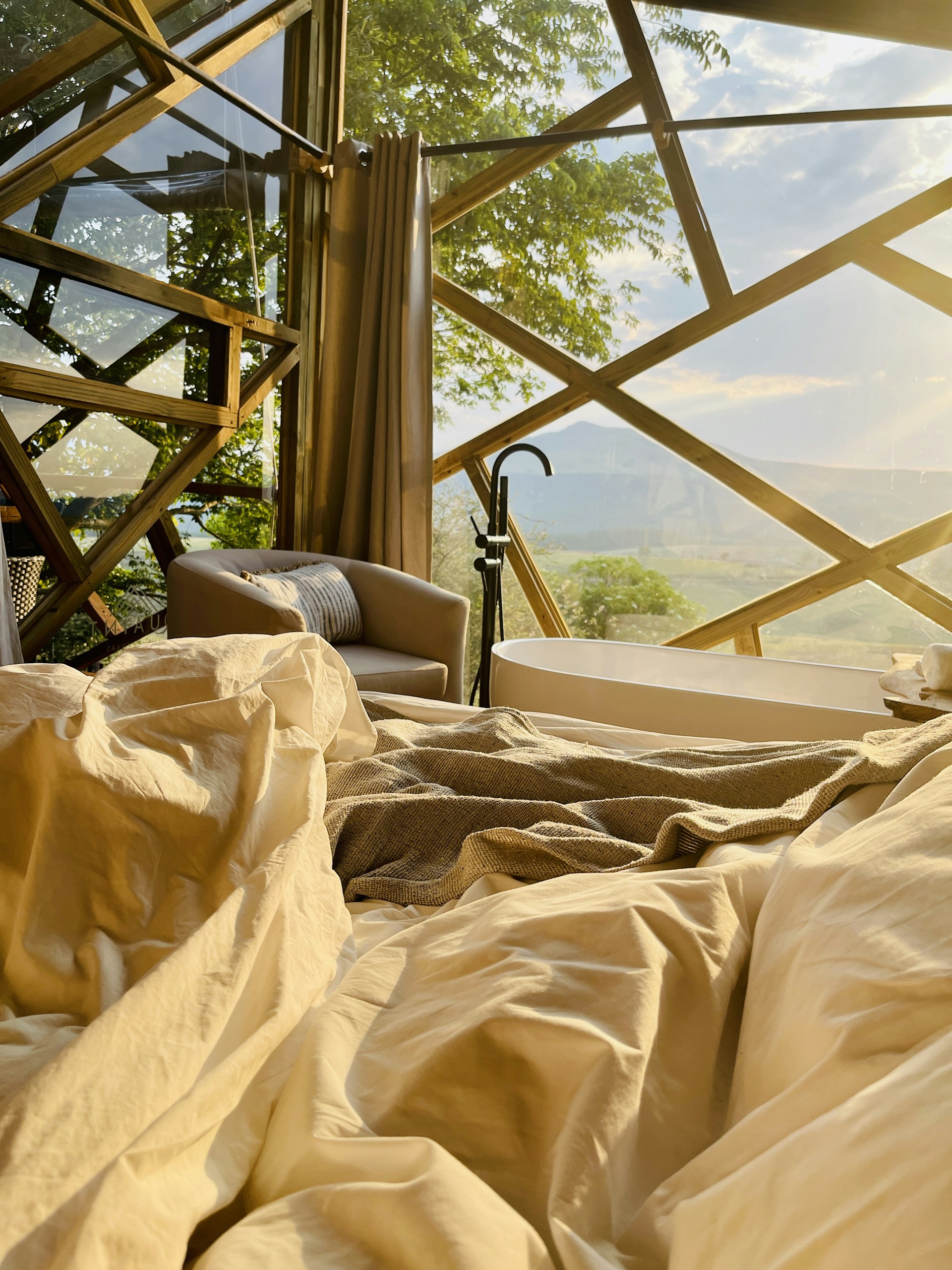 A serene early morning view of the grandhotel space's spacious suite, bathed in soft natural light highlighting elegant architectural details and warm neutral tones.