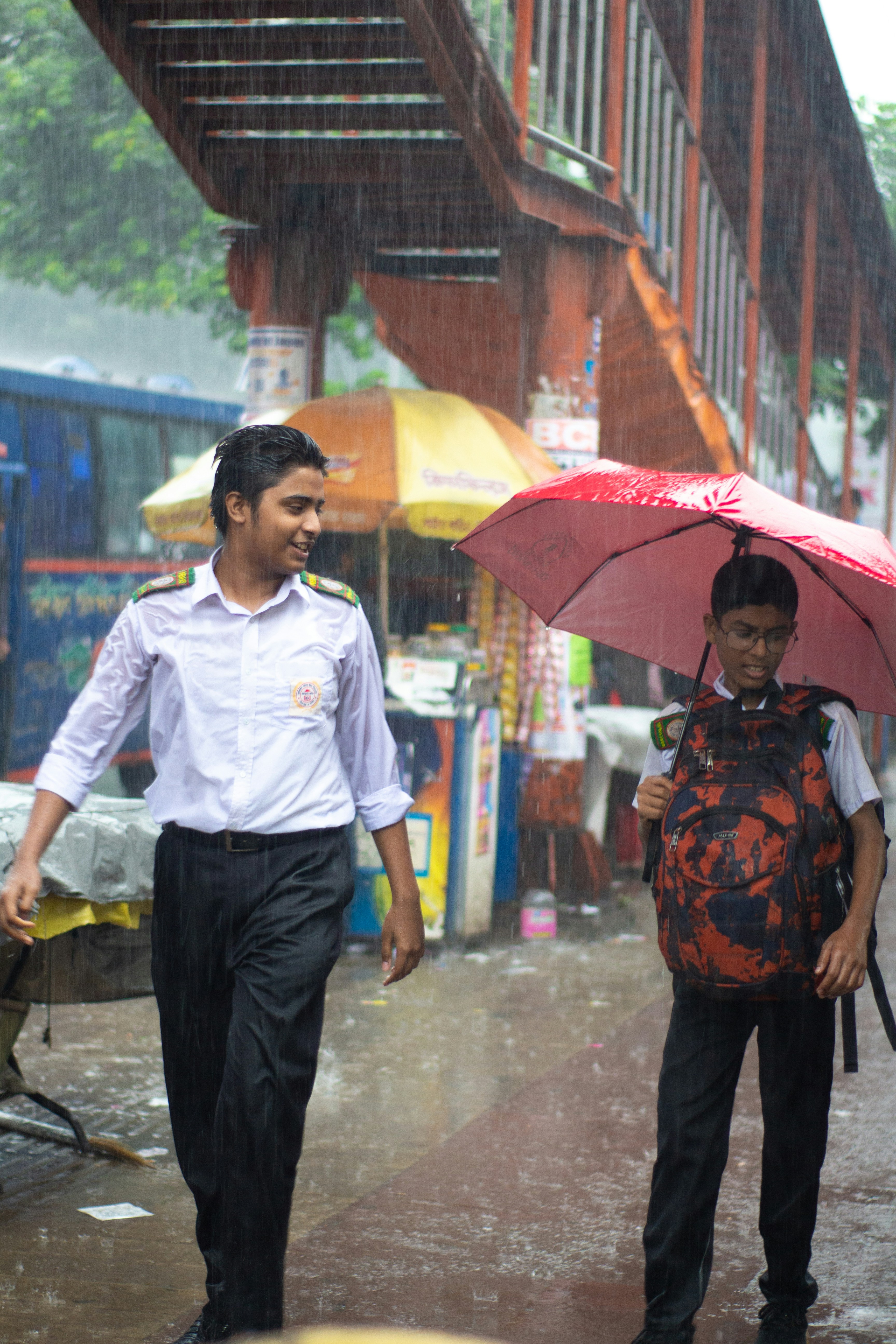 a man holding an umbrella walking with a woman