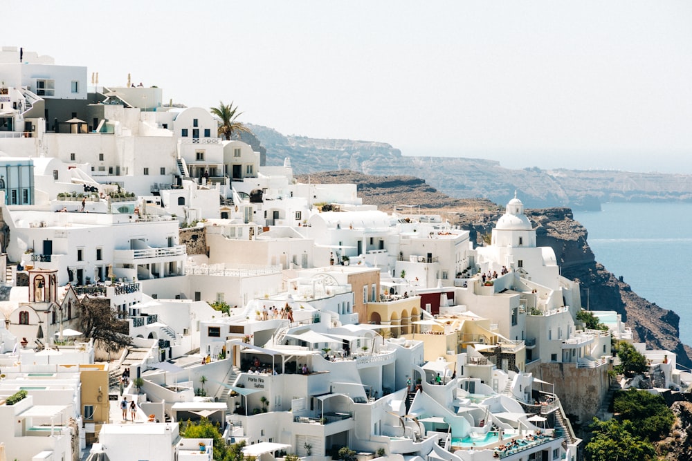 a city with white buildings and a body of water in the background