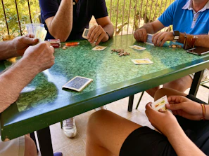 A group of diverse players enjoying an in-person poker game around a table.