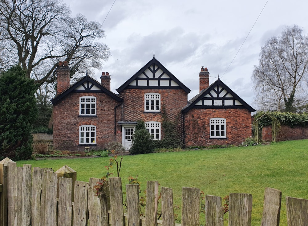 a brick house with a fence in front of it