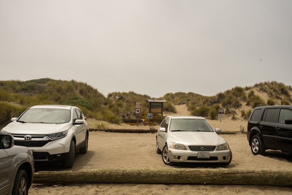 a group of cars parked on a dirt road