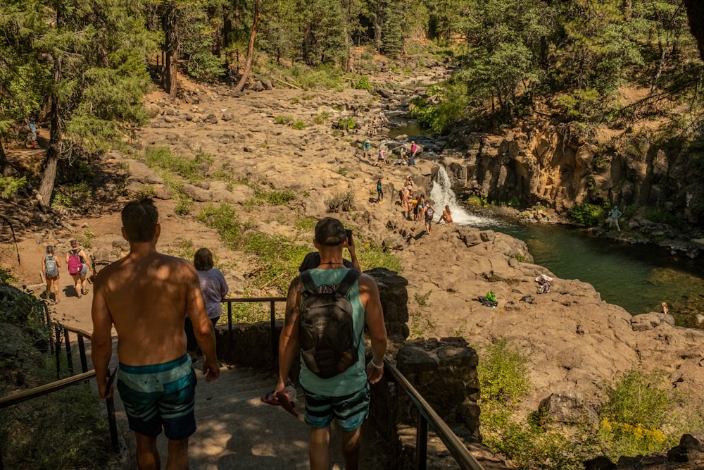 Un gruppo di persone che camminano su un sentiero vicino a una cascata
