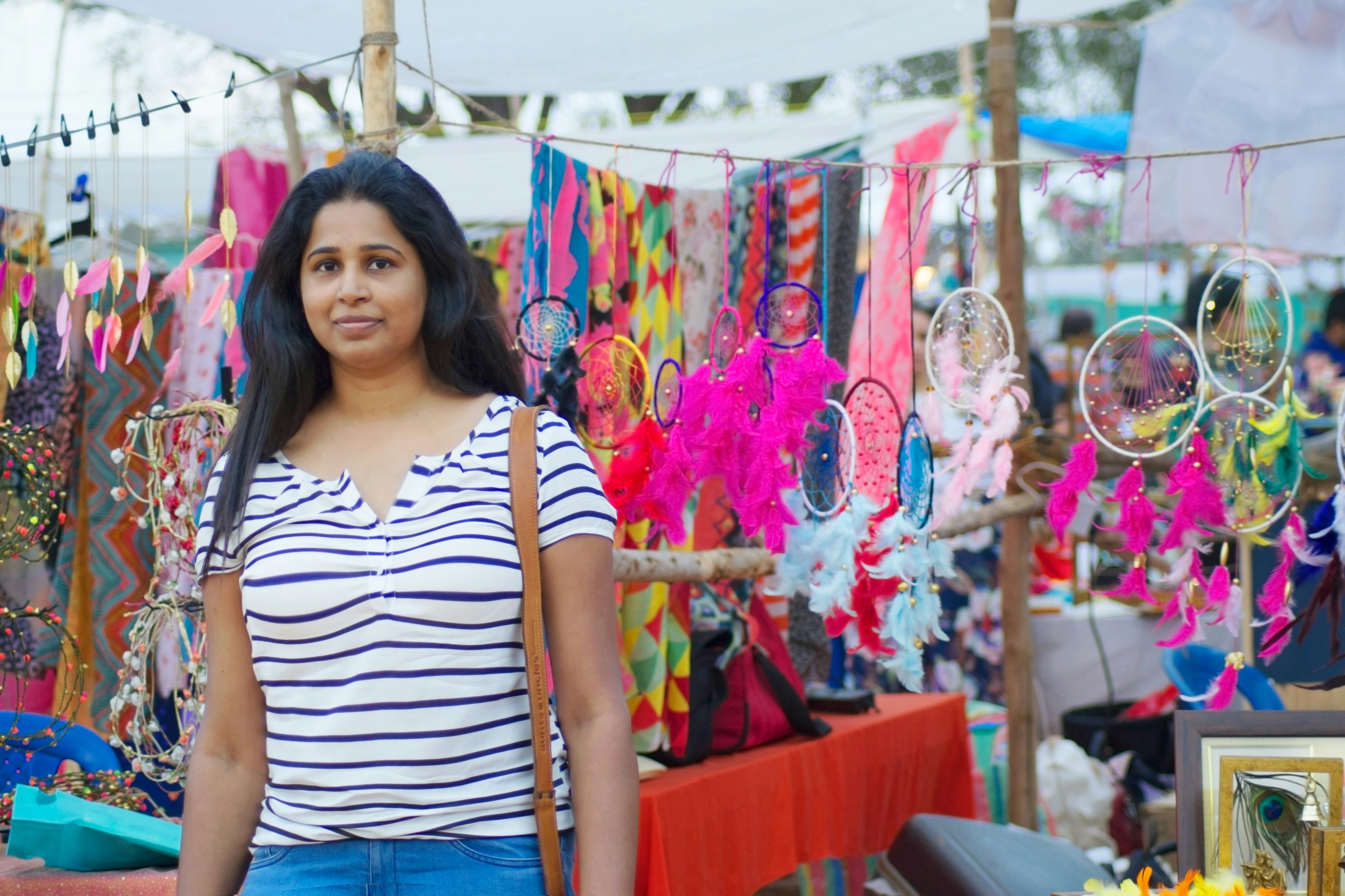 Woman standing at a vibrant outdoor craft market