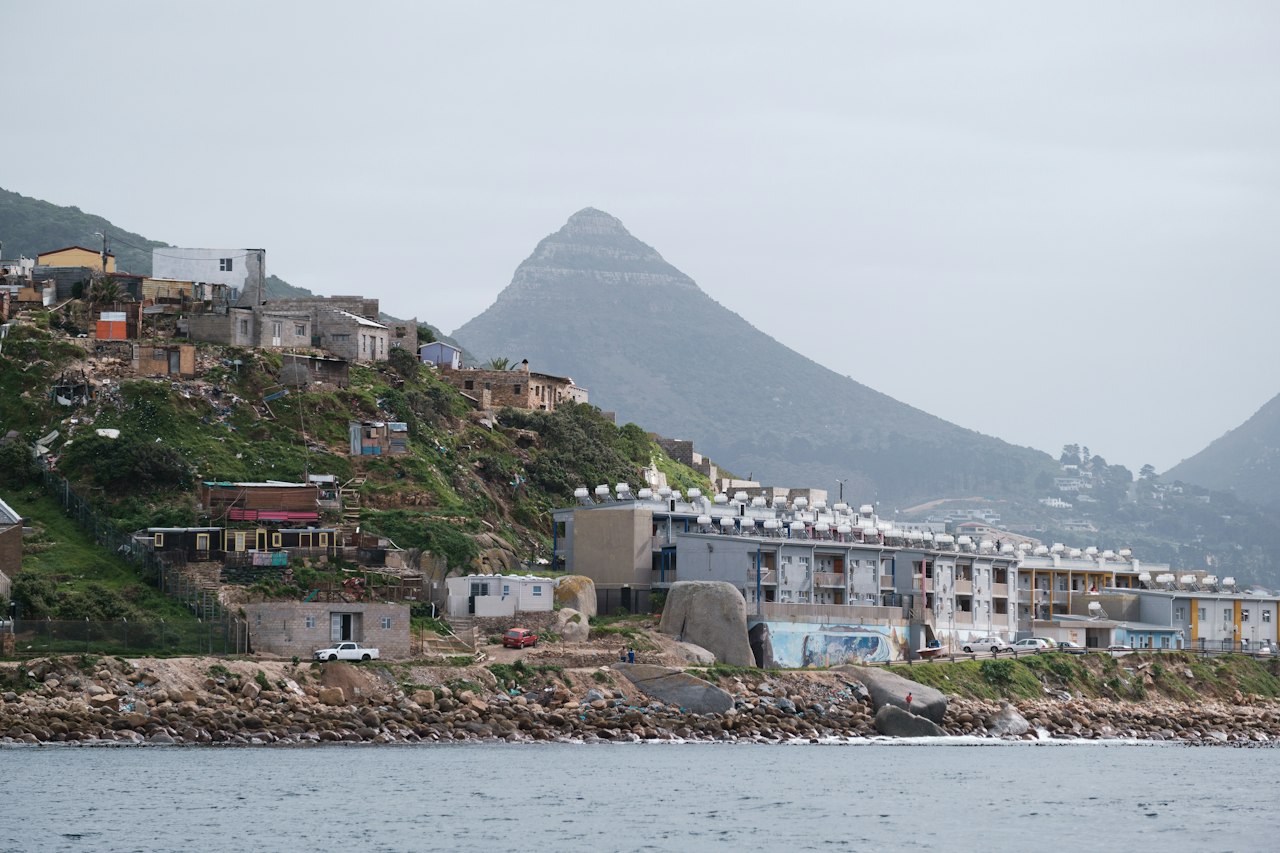 Homes built up a hillside beside the sea near Cape Town