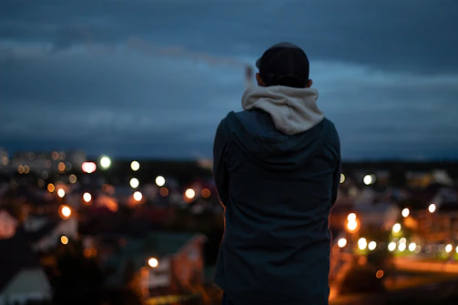 Movement hoodie draped over a chair with a city skyline blurred in the background at dusk.