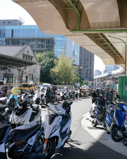 a large group of motorcycles parked under a bridge