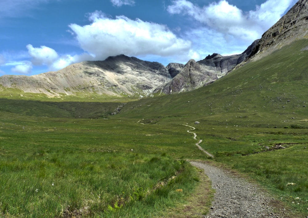 a dirt road in a valley between mountains