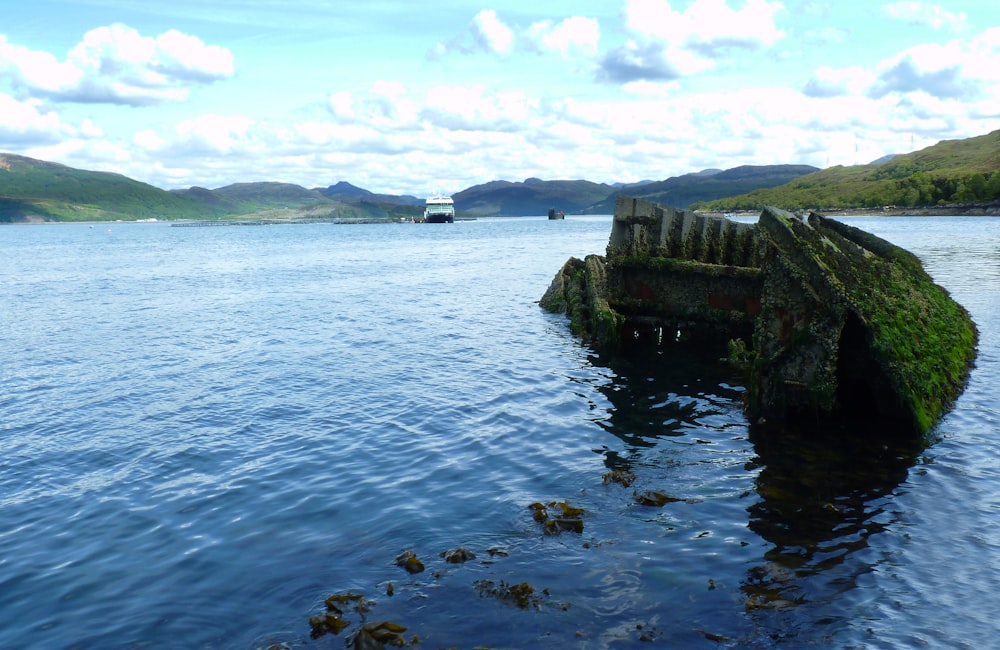 a rocky cliff next to a body of water