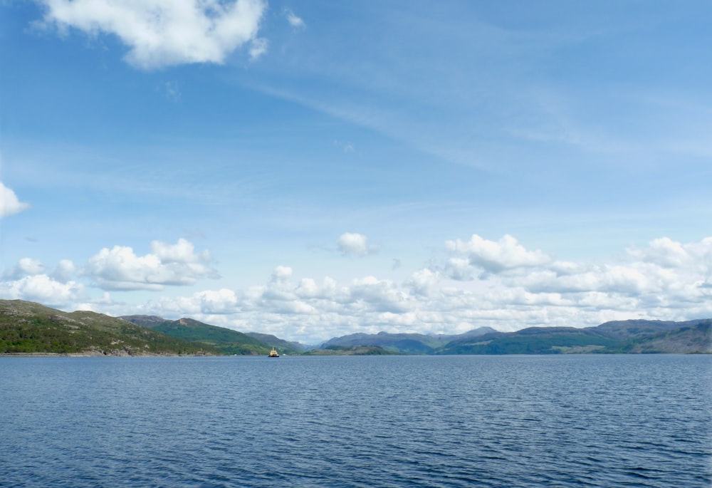 a body of water with hills in the background