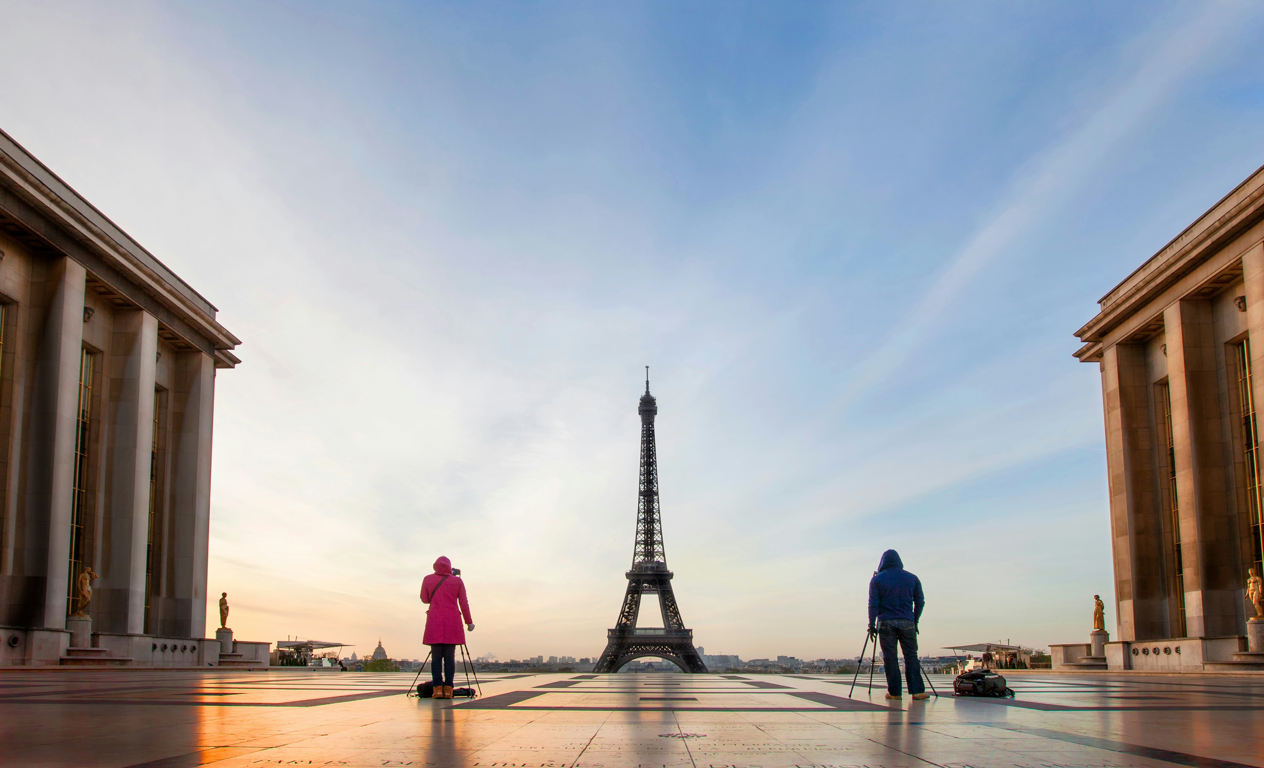 a man and a woman walking towards the eiffel tower, Taking photos of the eiffel tower