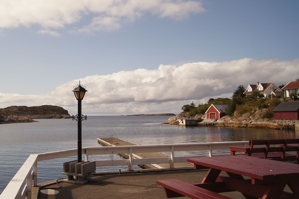 a body of water with a dock and a lamp post