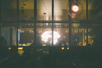 Evening view of the bar area with soft ambient lighting and happy patrons.