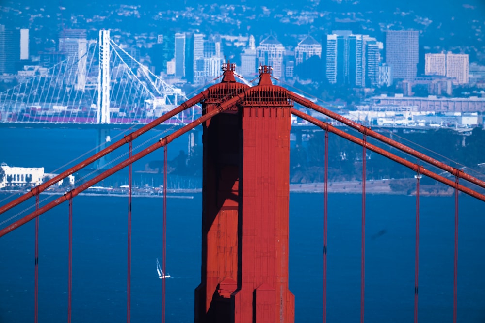 a red bridge with a city in the background