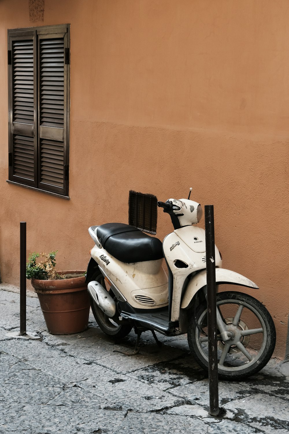 a white and black scooter parked next to a building