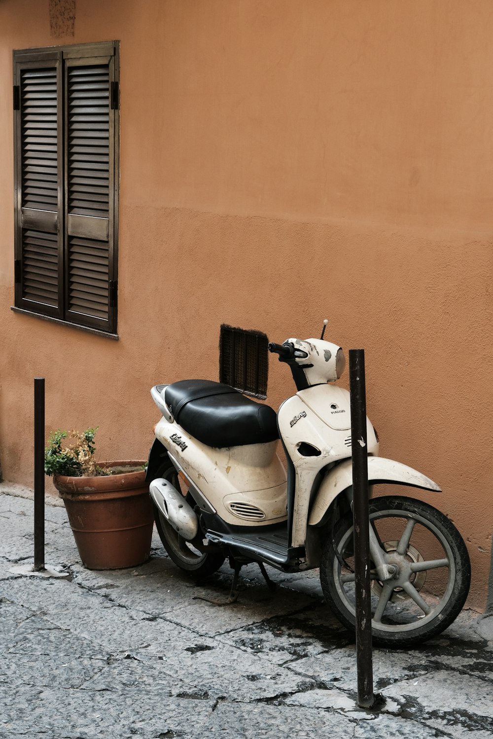 Un scooter blanco y negro estacionado al lado de un edificio