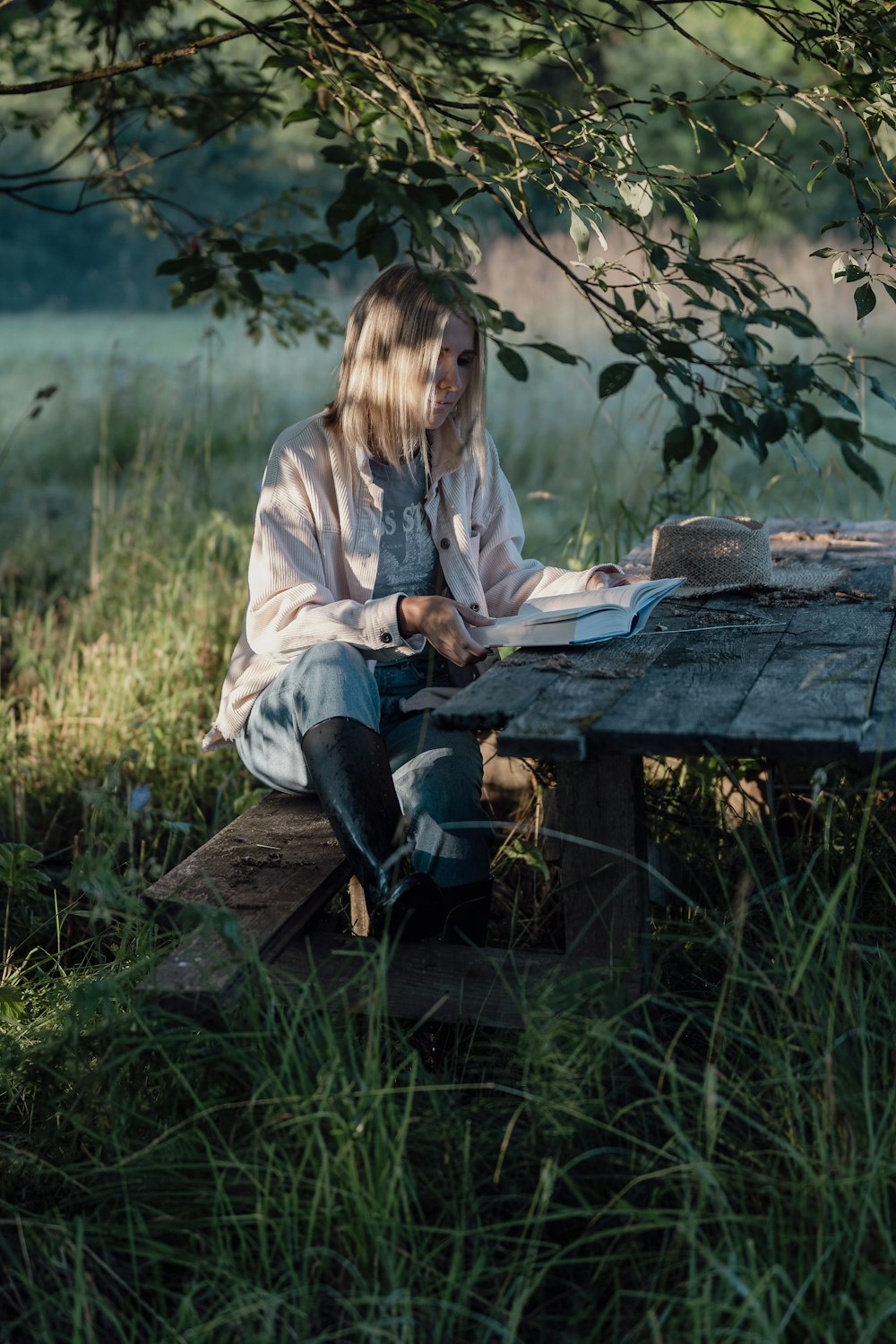 a person sitting on a bench reading a book