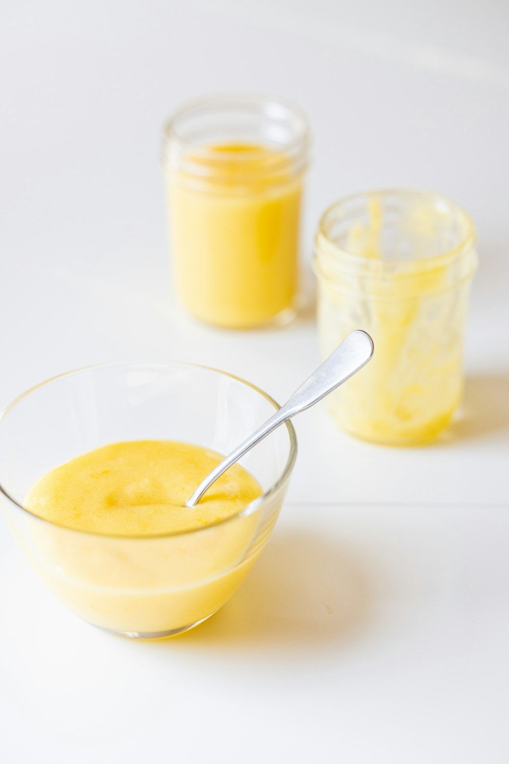 a bowl of yellow liquid with a spoon in it