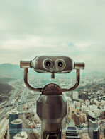 a large metal object with a city in the background