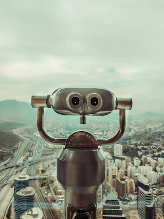a large metal object with a city in the background