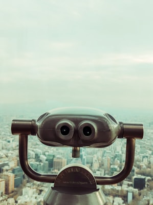 a telescope with a city in the background