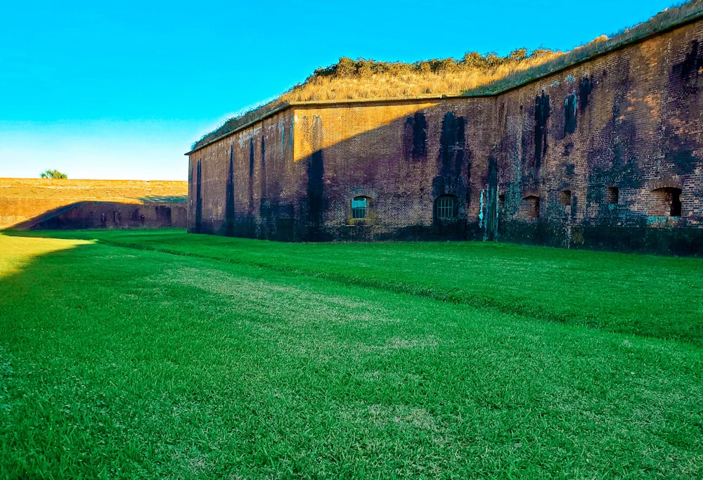 a stone building with grass in front of it