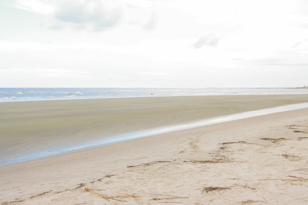 a sandy beach with water in the background