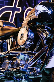 Close-up of a matte black Harley-Davidson engine with custom chrome detailing under bright workshop lights.