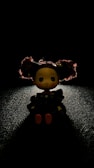 Close-up of a handcrafted crochet doll with dark moody lighting.
