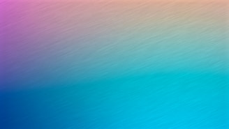 A gradient background featuring a smooth transition from a warm pink and orange hue at the top to a cooler blue and teal shade at the bottom. The texture appears brushed, adding a subtle sense of movement across the image.