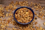 Walnuts and watermelon seeds displayed on a wooden table, highlighting texture.
