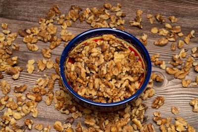 Walnuts and watermelon seeds displayed on a wooden table, highlighting texture.