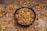 A close-up of a bowl filled with fresh, raw walnuts on a wooden table.