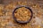 A close-up of a bowl filled with fresh, raw walnuts on a wooden table.