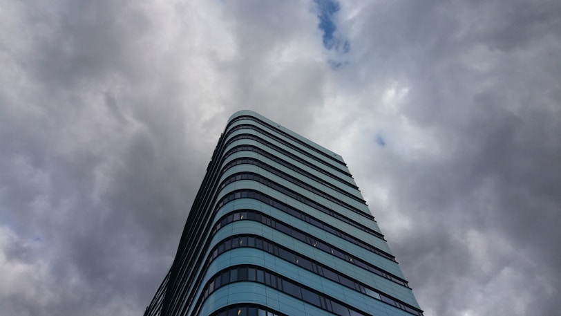 a tall building with clouds in the sky