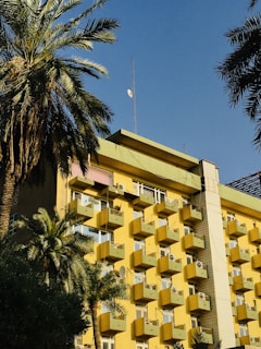 a building with balconies and palm trees