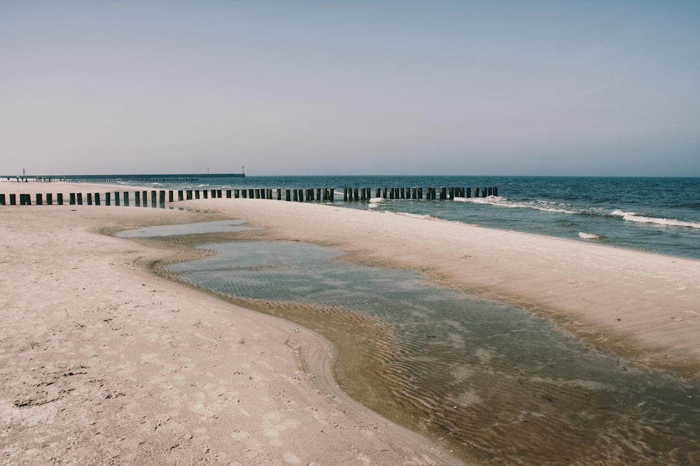 a sandy beach next to a body of water